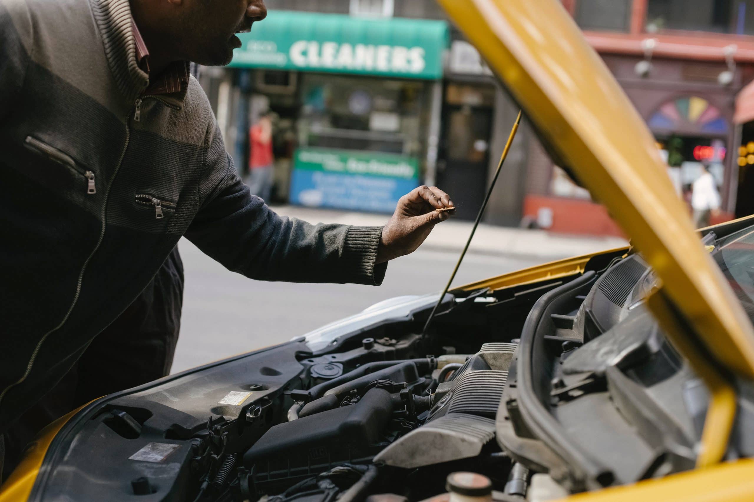 mechanic looking at the engine of a car