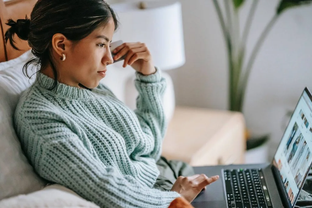 woman thinking about bankruptcy while browsing the internet on laptop